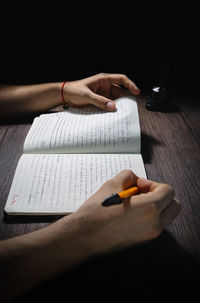 Close-up of hand holding book on table