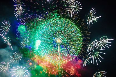 Low angle view of firework display against sky at night