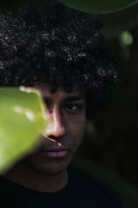 Close-up portrait of man by leaf