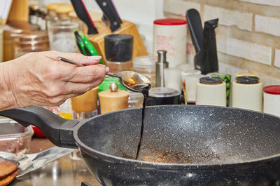 Cropped hand preparing food in kitchen