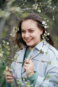 Portrait of a beautiful smiling joyful girl in cherry blossoms in spring