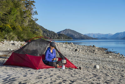 Woman relaxing at camp at the nahuel huapi lake in patagonia