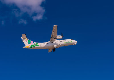 Low angle view of airplane flying against sky