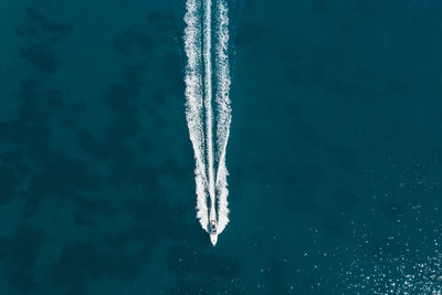 Airplane flying over sea against blue sky