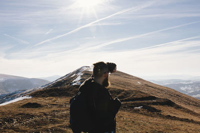 Man standing on mountain against sky