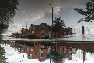 Reflection of buildings in lake against sky