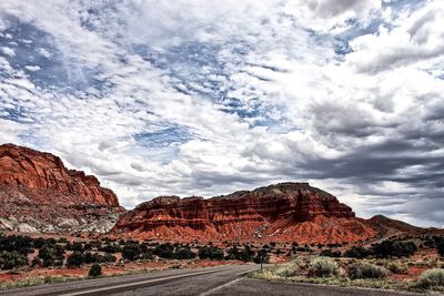 View of rock formations in desert against cloudy sky