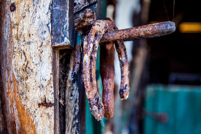 Close-up of rusty horseshoes hanging on nail