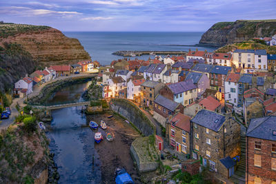 High angle view of townscape by sea against sky