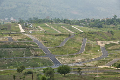 High angle view of road amidst trees on field