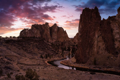 Rock formations on landscape against sky during sunset