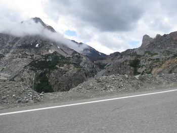 Road by mountains against sky