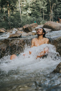 Woman relaxing on rocks by water