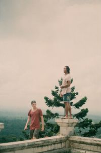 Full length of man standing by tree against sky