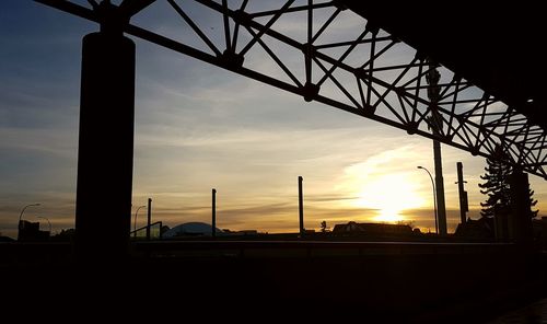 Silhouette bridge against sky during sunset