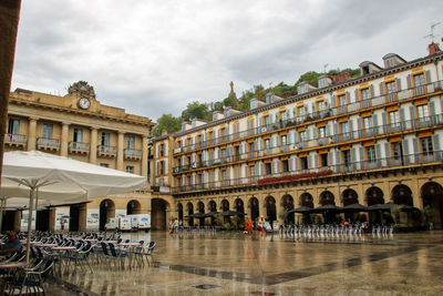 Buildings in city against cloudy sky