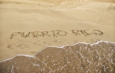 Close-up of text on sand at beach