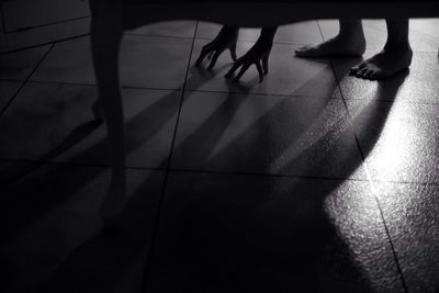 Low section of silhouette people standing on tiled floor