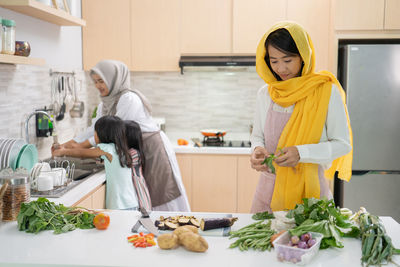 Full length of woman standing in kitchen at home