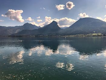 Scenic view of lake by mountains against sky