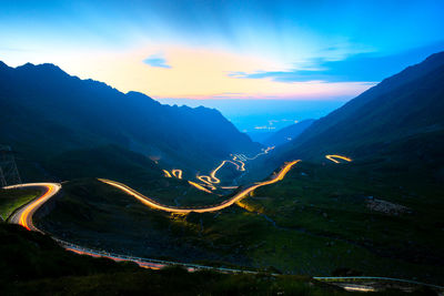 High angle view of illuminated mountains against sky at sunset