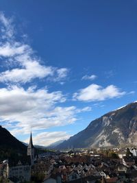 Town by mountains against sky