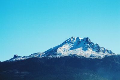 Snowcapped mountains against clear blue sky