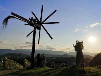 Traditional windmill on field against sky