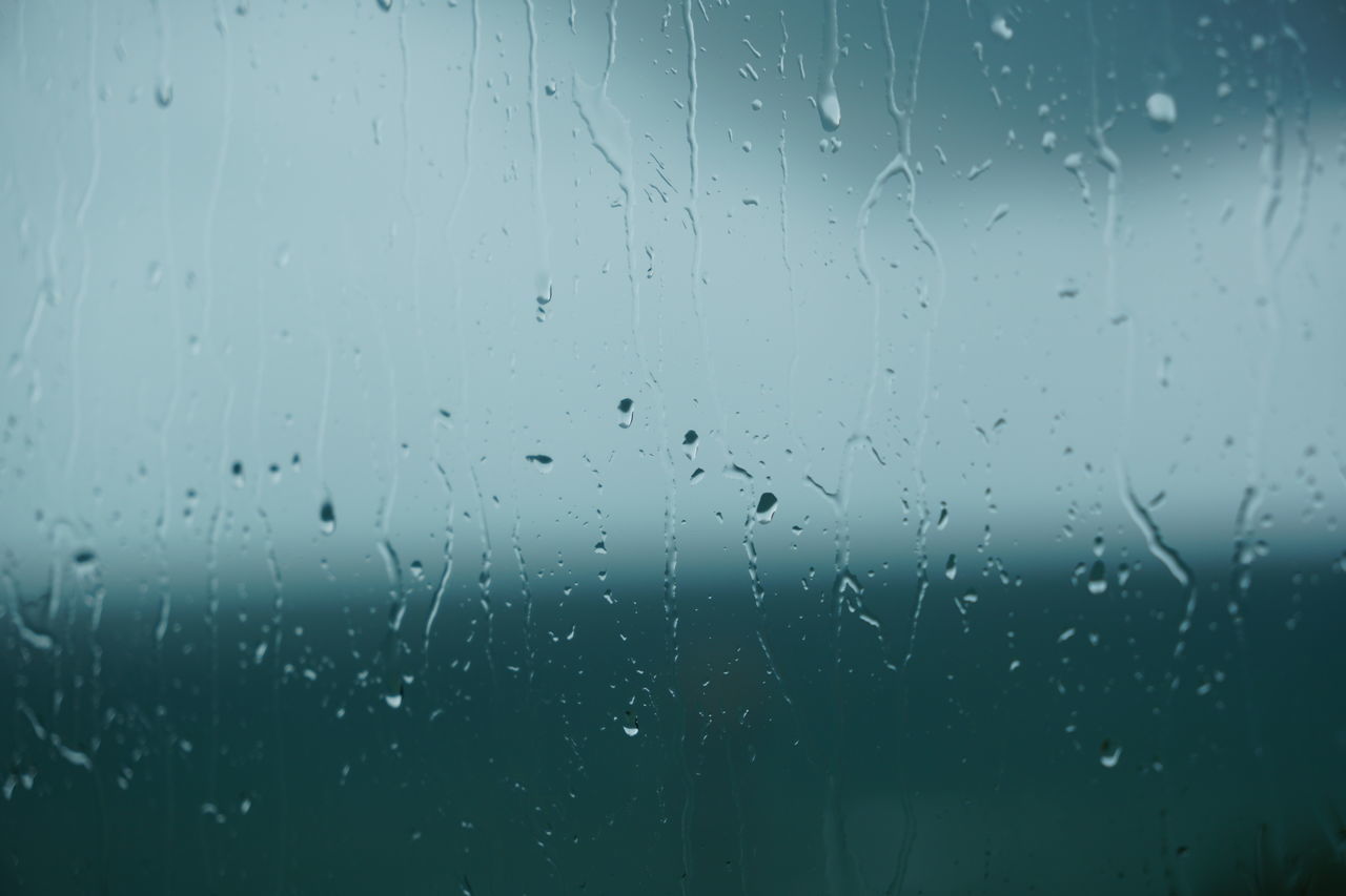 CLOSE-UP OF RAINDROPS ON GLASS WINDOW