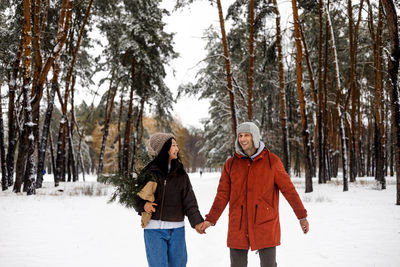 Portrait of smiling woman standing on snow covered landscape