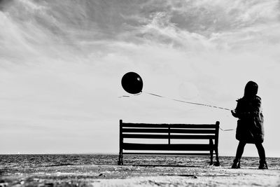 Man standing on balloon against sky