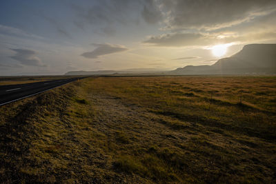 Scenic view of agricultural field against sky during sunset