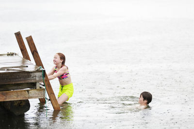 Brother and sister at sea in rain