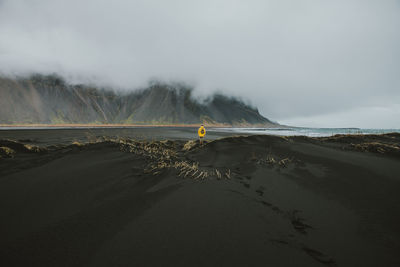 Man on black sand in desert