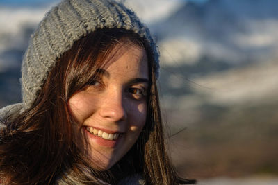 Close-up portrait of smiling young woman against sky