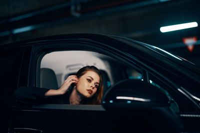 Portrait of young woman sitting in car