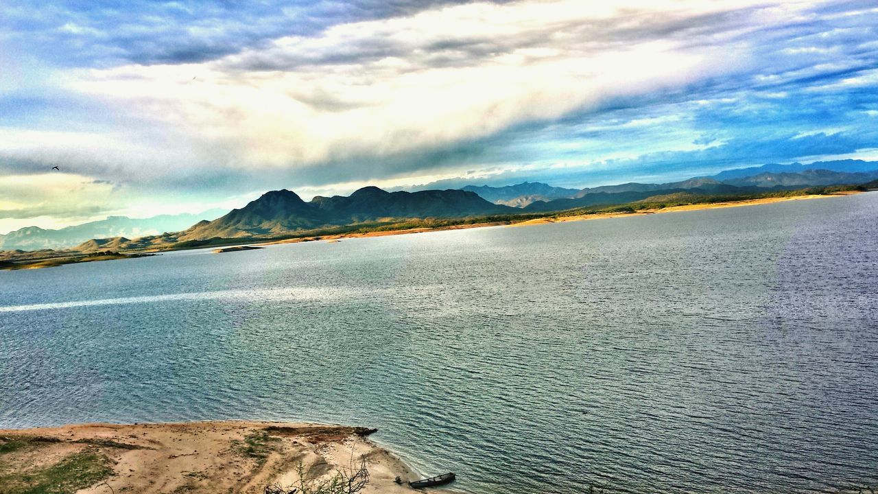 sky, mountain, water, cloud - sky, tranquil scene, scenics, sea, tranquility, beach, beauty in nature, mountain range, cloudy, sand, nature, shore, cloud, idyllic, coastline, outdoors, day