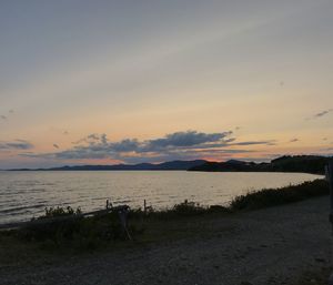 Scenic view of lake against sky at sunset