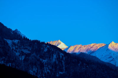 Low angle view of mountain against clear blue sky