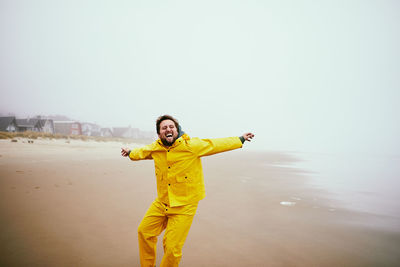 Happy man at beach against sky