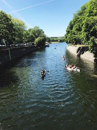 People swimming in river against sky