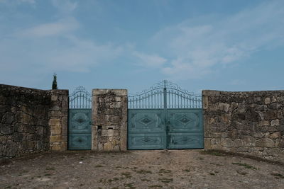 Closed gate against sky