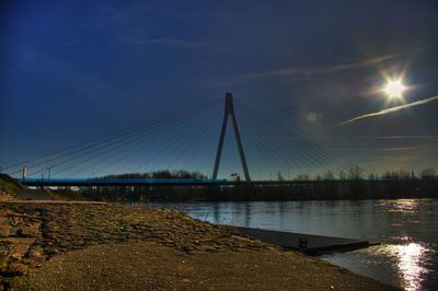 Suspension bridge over river against sky