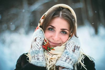 Portrait of smiling woman with scarf in snow