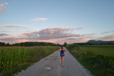 Rear view of woman walking on road