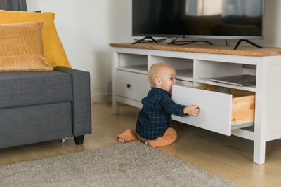 Rear view of woman sitting on floor at home