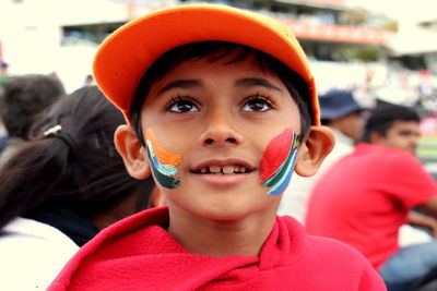 Close-up of smiling boy with face paint sitting outdoors