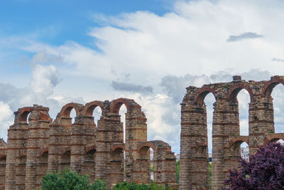 Low angle view of old ruin building against cloudy sky