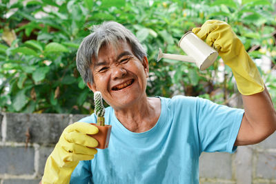 Smiling senior woman holding plants