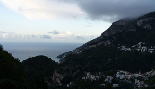 Scenic view of sea and mountains against sky